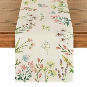 Détail d'un chemin de table floral avec marguerites et lavande sur bois foncé