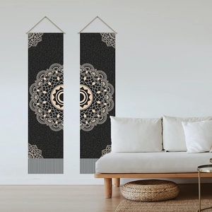Set of two black Bohemian mandala wall tapestries with wooden poles in a modern living room