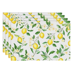 Close-up of four linen placemats with watercolor lemon prints and detailed stitching