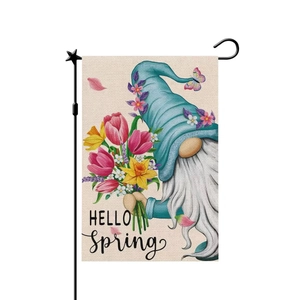Detail of linen garden flag with gnome design and metal stand on white background