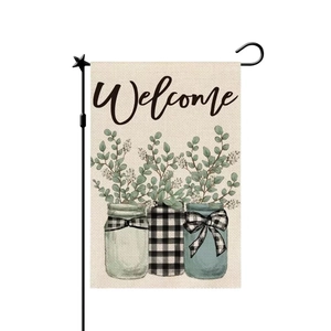 Close-up of Welcome garden flag with eucalyptus jars on linen fabric texture with metal pole