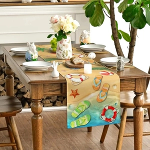 Detail of beach themed table runner with flip-flops and lifebuoy prints on wooden table