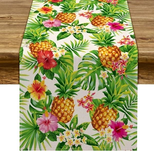Detail of floral table runner with pineapple and hibiscus print on linen fabric
