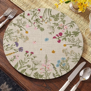 Detailed view of round linen placemat featuring vibrant floral wildflowers on dark wood table