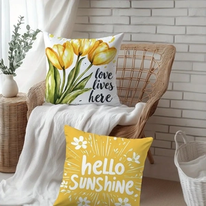 Spring tulip and daisy pillow covers with Love Lives Here text on a wicker chair