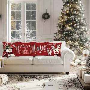 Detailed view of four red Christmas pillow covers featuring snowmen and deer on a sofa