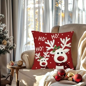 Close-up of a festive red Christmas pillow with white reindeer on a beige sofa