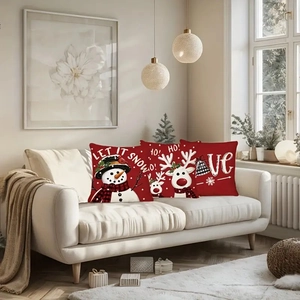 Three-piece Christmas linen pillow cover set with snowman and reindeer on a sofa