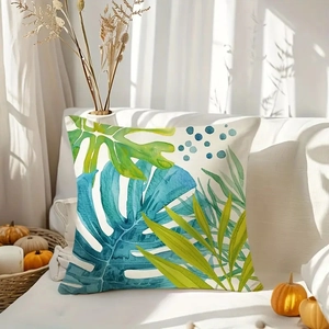 Tropical plant throw pillow set with watercolor leaves on a white sofa in a bright room