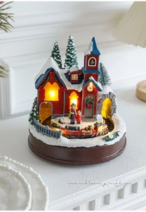 Détail d'un village de Noël avec un train rotatif et des lumières LED chaleureuses
