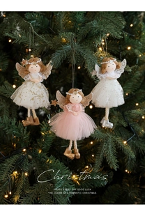 Detailed close-up of plush angel ornaments with antler wings on a glowing Christmas tree