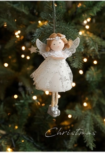 Detail of Christmas angel plush with silver wings hanging on a festive tree branch