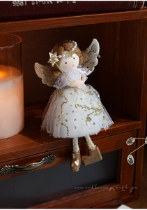 Detail of plush angel girl ornament with golden sequins, lace dress, and star scepter