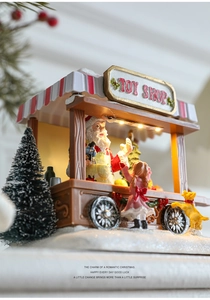 Detailed close-up of a lit resin Toy Shop miniature with Santa for Christmas decor