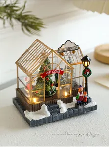 Close-up of lighted Christmas greenhouse resin house with Santa and festive miniatures