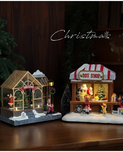 Close-up of light-up Christmas toy shop and greenhouse miniature resin desktop decor
