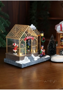 Detail of a lighted Christmas greenhouse miniature with LED tree and festive figures