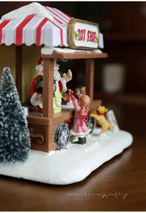 Close-up of a resin Christmas toy shop miniature with glowing lights and snowy details