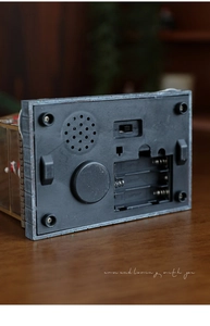 Detailed base of glowing Christmas resin house showing battery compartment and switches
