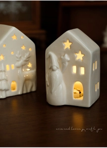 Detail of white ceramic Christmas house lamps with hollow star patterns and warm LED glow