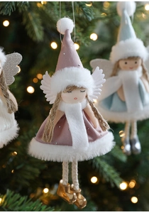 Detail of pink plush angel ornament with silver sequins on a lighted Christmas tree