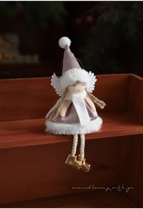 Detail of plush Christmas angel doll with sequined pink dress and golden bells