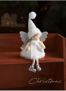 Detail view of a plush Christmas angel girl doll with white knit hat and silver wings