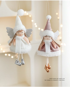 Close-up of plush angel doll ornaments with silver wings and bells for Christmas tree