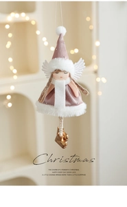 Close-up of plush angel girl pendant with velvet dress and bell for Christmas tree