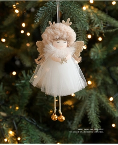 Detail of Christmas angel plush doll with golden antlers, wings and bells on Xmas tree