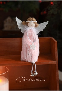 Detail of plush Christmas angel with silver wings and bells on warm wood background