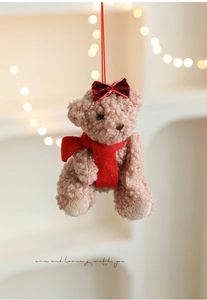 Detailed view of plush teddy bear with curly fur, red bow and scarf for Christmas