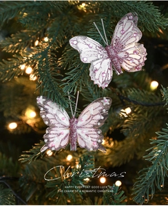 Dettaglio di farfalla natalizia rosa con glitter e gemme sui rami dell'albero
