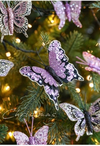 Dettaglio di una farfalla glitterata viola con paillettes su un albero di Natale