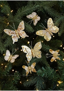 Dettaglio di clip a farfalla dorate scintillanti con glitter su un albero di Natale