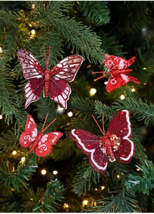 Dettaglio di clip a farfalla rosse glitterate con paillettes su albero di Natale