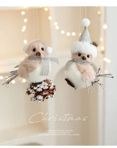 Detail of plush bird ornaments with festive hats and real pine cones on warm bokeh background