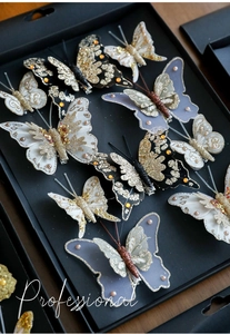 Dettaglio di fermagli a farfalla glitterati con paillettes, perline e base a becco d'anatra
