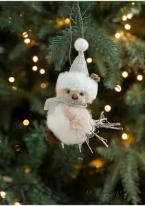 Macro detail of plush gray bird ornament with glitter hat on a festive Christmas tree