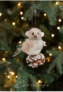 Detail of plush bird ornament with silver scarf on snowy pine cone for Christmas tree