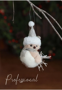 Detail of plush bird ornament with silver sequin hat and scarf on a festive branch
