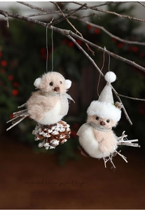 Detailed view of plush bird ornaments with pine cones on natural branches for Christmas