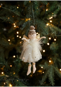 Plush Christmas angel doll with white tulle skirt hanging on a glowing Xmas tree branch