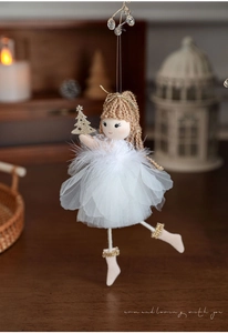 Detail of plush angel girl ornament with white tulle skirt and gold mini Christmas tree