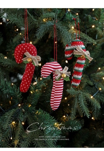 Close-up of three festive fabric candy canes with bells and bows on a Christmas tree