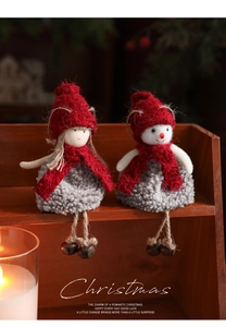 Cozy plush Christmas dolls with red knit scarves and bells sitting on a wooden shelf