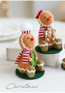 Close-up of felt gingerbread man figurines with scarves and trees on base