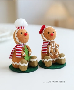 Close-up of handmade gingerbread man plush dolls in festive red and green Christmas outfits