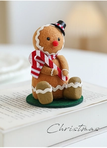 Detail of felt gingerbread man figurine with mini top hat and candy cane for Christmas decor