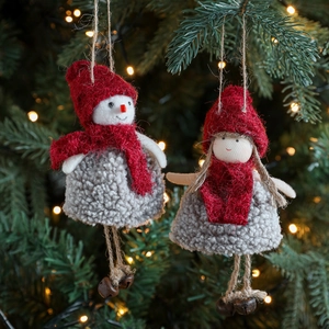 Plush Christmas snowman and girl ornaments with bells hanging on a festive Xmas tree
